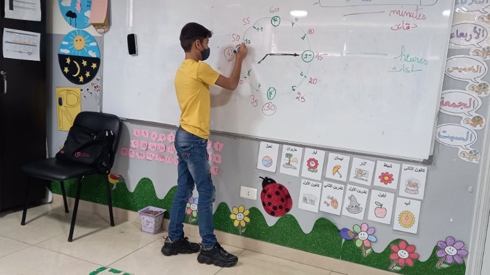 Moe a 10 year old boy writes on a whiteboard in a JRS education centre in Lebanon 