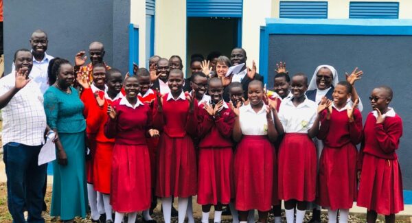 students of St Mary's Assumpta school in Adjumani wave at camera with teachers.