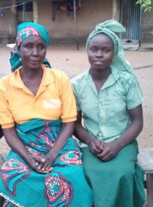 Agal sits with her mother outside her home