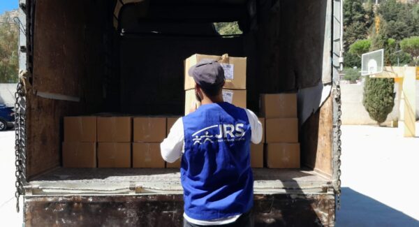 Food aid from a humanitarian truck is being sorted by JRS aid worker.