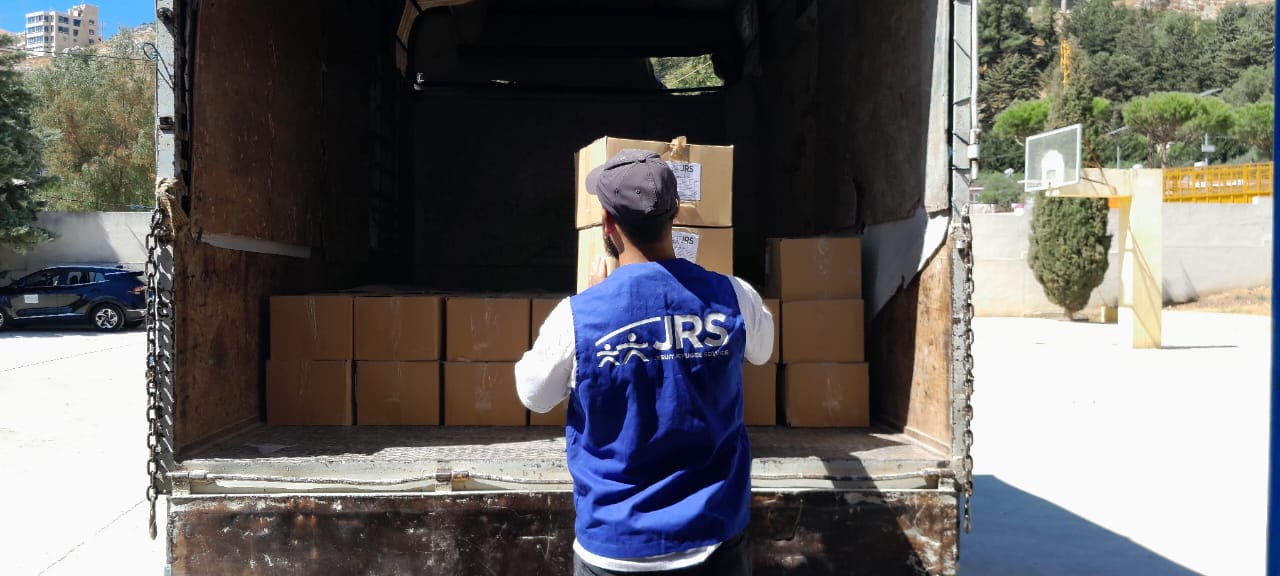 Food aid from a humanitarian truck is being sorted by JRS aid worker.