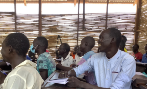 teachers smile at the desk during a teacher-training workshop. 