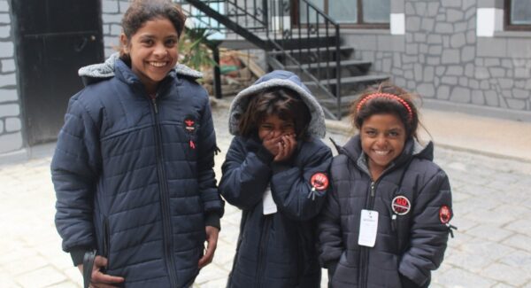 Syrian children smile in coats to keep them warm during the cold winter months.