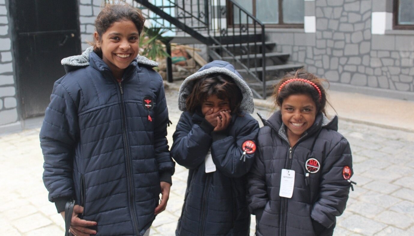 Syrian children smile in coats to keep them warm during the cold winter months.